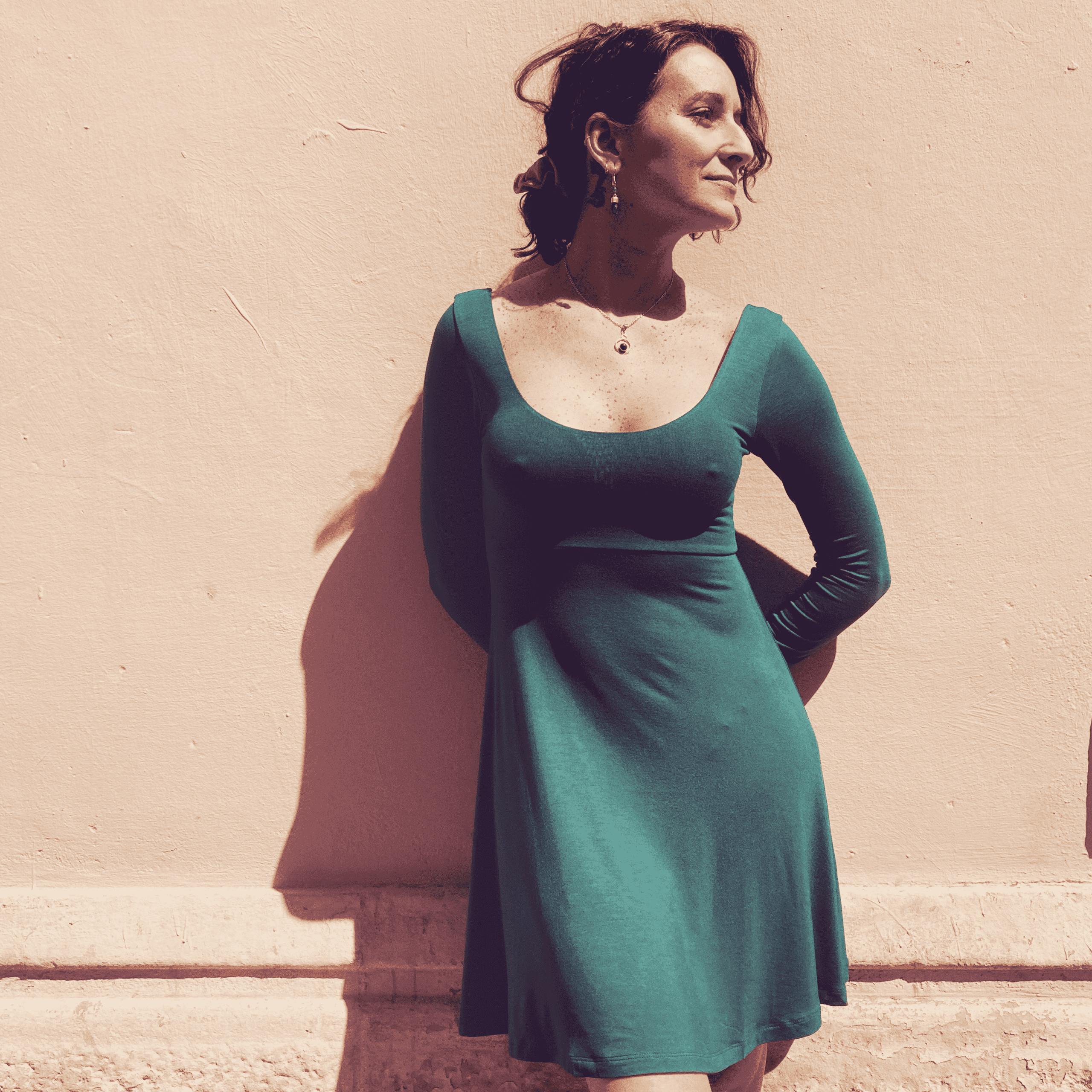 clienta de japamala luciendo el vestido bailarina con mangas largas , en color verde. En el exterior de la tienda, en el barrio de Gracia , Barcelona.