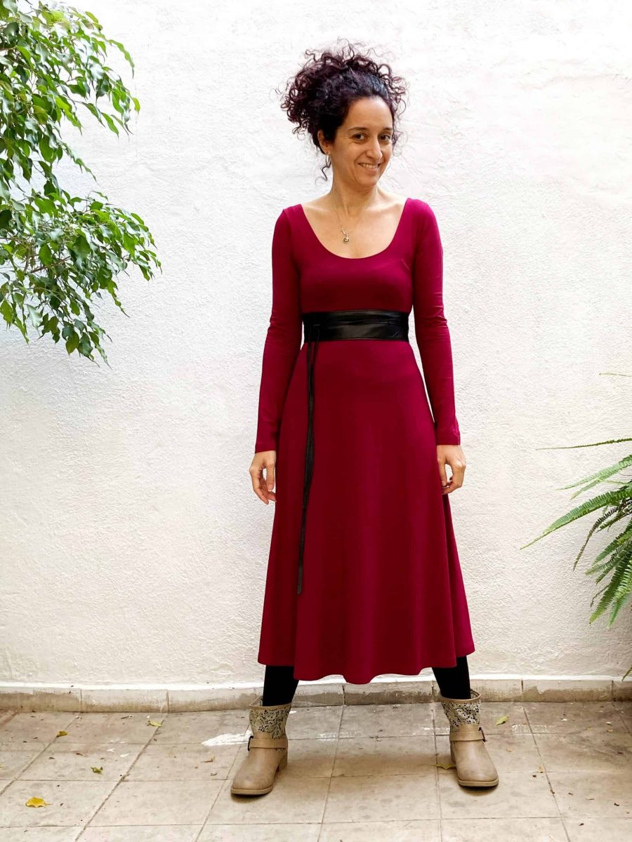 sonia la clienta con su vestido bailarina de punto de viscosa en rojo, posando en el patio interior de la tienda en barcelona