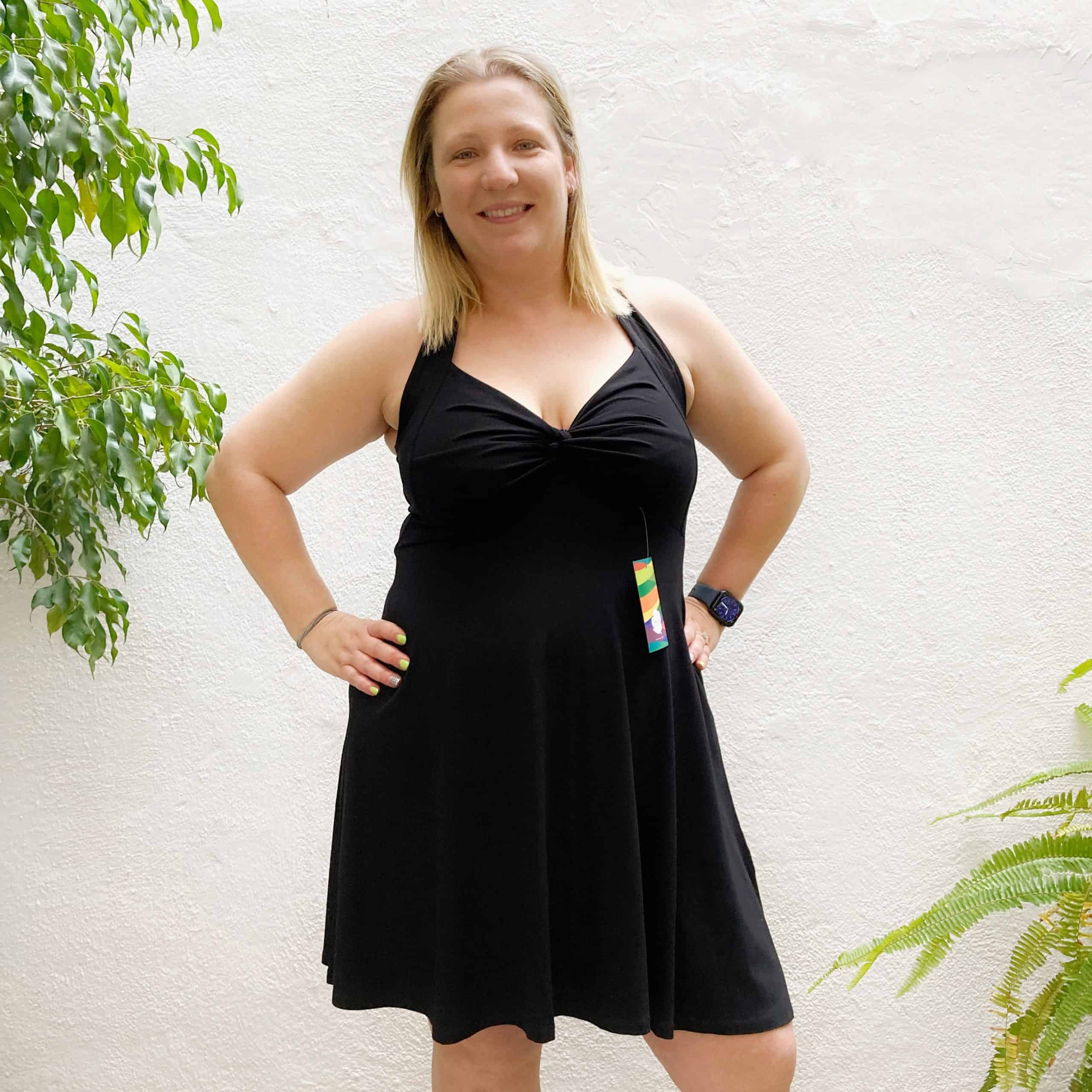 clienta feliç de japamala provant un vestit vintage d'estiu en color negre. interior de la botiga amb ambient tranquil i llum natural