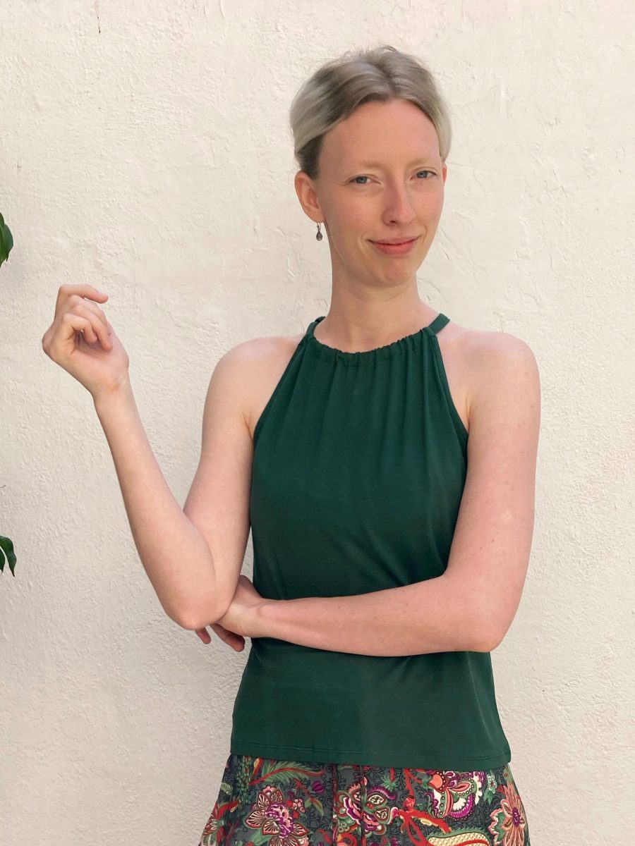 Customer wearing her new green top necklace for the summer. in the inner courtyard of the store in gracia. 