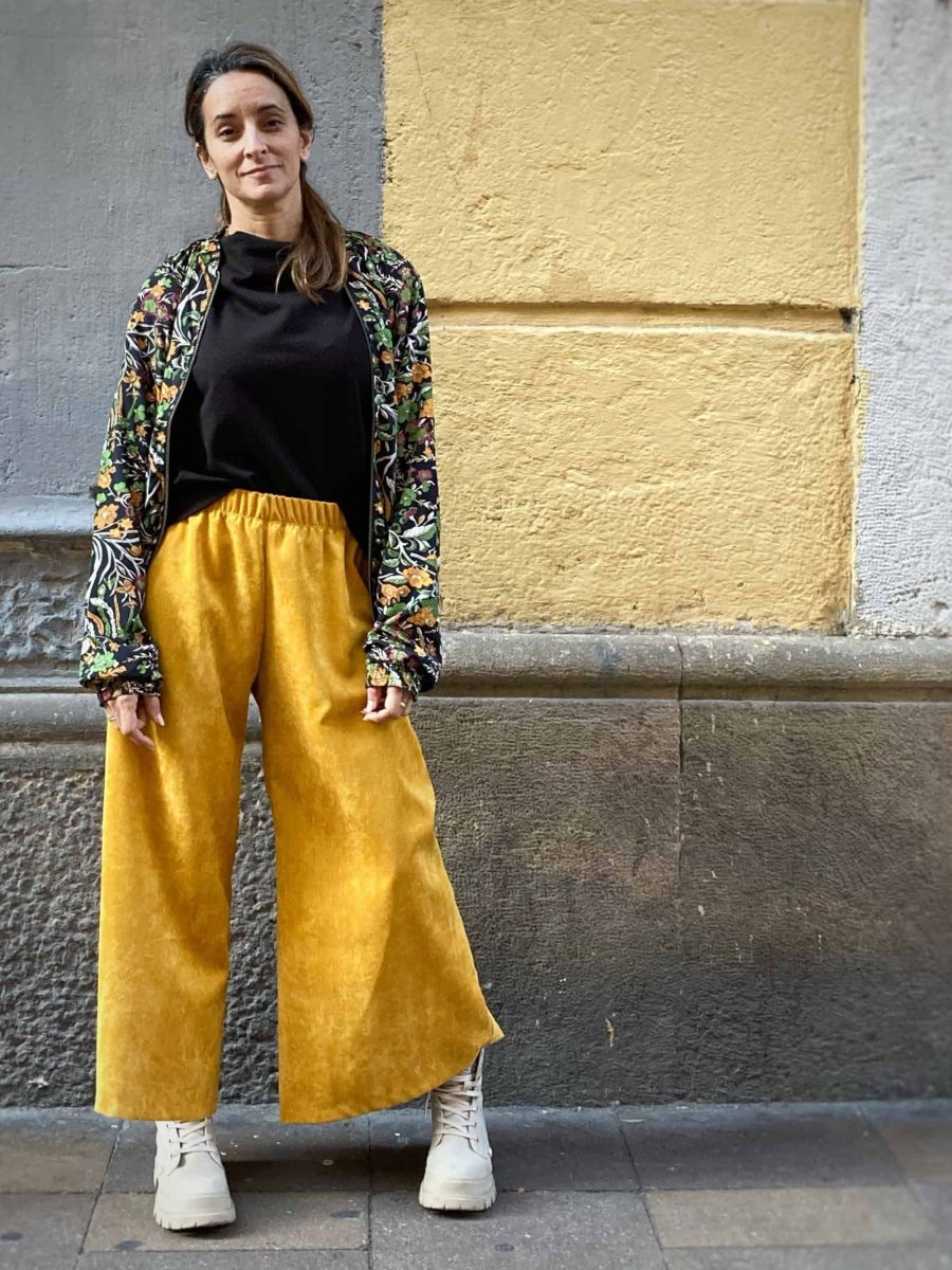 clienta de japamala luciendo el pantalón cropped en pana de color mostaza, en las calles del icónico barrio de Gracia en Barcelona.